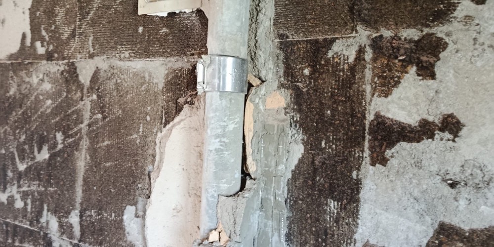 Freigelegte Wand mit Leitungsrohr